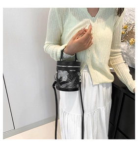 Dettaglio di una mini borsa a secchiello nera con motivo retrò argento e cerniera argentata
