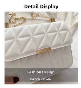 Close-up of white quilted leather bag with gold rectangular clasp and woven chain strap