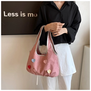 Detailansicht der rosa Canvas-Tasche mit bunten Herz-Patches und metallischen Kanten