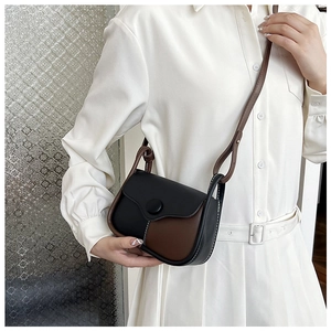 Detail of vintage crossbody bag with contrast stitching and round buckle on a model