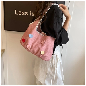 Detailaufnahme einer rosa Canvas-Tasche mit bunten 3D-Herzen und silberner Paspelierung