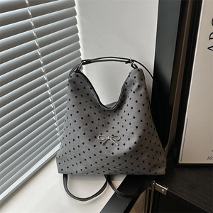 Sac cabas gris à imprimé cœurs et nœud argenté sur un rebord de fenêtre