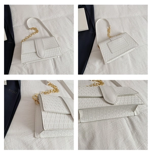 Detail view of white flap bag with geometric triangle texture and gold chain strap