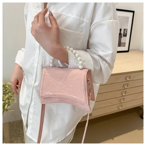 Detailed side view of pink marble pattern handbag with pearl handle on a model