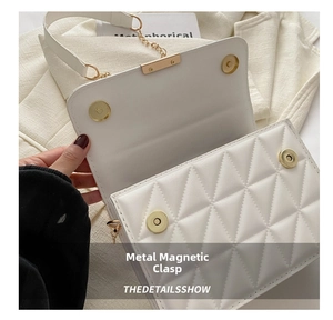Detail of the high-quality magnetic buckle and diamond lattice on the white handbag