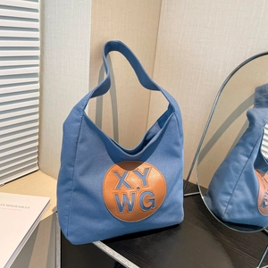 Blue canvas tote bag with brown leather XY WG logo patch and casual shoulder strap style