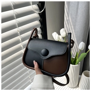 Detailed view of vintage crossbody bag with contrast stitching and large round buckle
