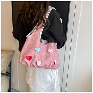 Seitenansicht der rosa Canvas-Einkaufstasche mit bunten Herz-Patches auf der Schulter