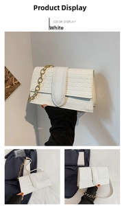 Detail of white rectangular flap bag with geometric triangle embossing and gold chain