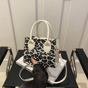 Chic leopard print mini tote bag with white leather straps and adjustable shoulder strap