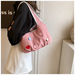 Detailansicht der rosa Canvas-Schultertasche mit bunten Herz-Patches und silberner Paspel