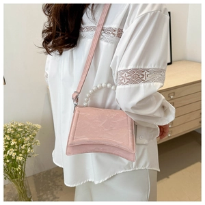 Close-up of pink marble texture handbag with pearl handle and curved base design