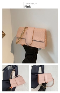 Detailed view of pink crossbody bag with geometric texture and gold chain strap
