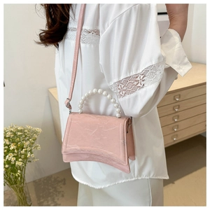 Detail view of pink marble texture handbag with pearl handle and hourglass curved bottom