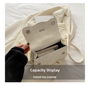 Interior view showing the capacity of this white pearl bow crossbody bag for essentials