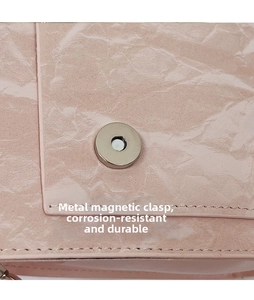 Macro detail of silver magnetic snap closure on pink pleated leather handbag