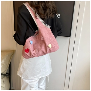 Detailansicht der rosa Segeltuchtasche mit bunten Herz-Patches und silbernem Metallrand