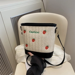 Straw bucket bag with strawberry embroidery, black leather trim and adjustable strap