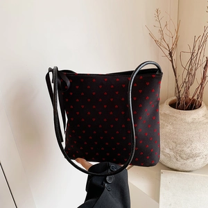 Borsa a secchiello nera con motivi a cuore rosso e decorazione con fiocco in seta