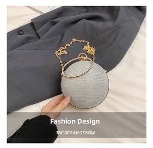 Detail of silver spherical evening bag featuring rhinestone-encrusted gold ring handle