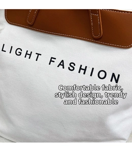 Detailed close-up of the canvas and leather stitching on the large Light Fashion tote bag