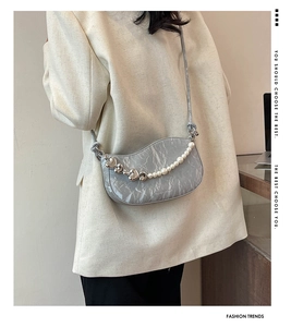 Detail of grey marble textured crescent bag with pearl and silver heart chain