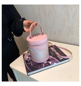 Dettaglio borsa a secchiello rosa con motivo dorato classico e manico in pelle pregiata