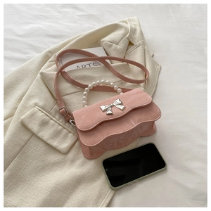 Pink handbag with pearl handle and silver butterfly detail on a beige jacket