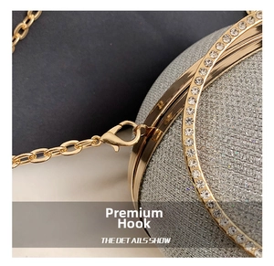 Macro detail of golden lobster clasp and metallic chain on a sparkling silver evening bag