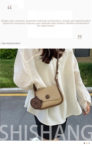 Détail du sac bandoulière beige avec bordure marron foncé et pendentif en forme d'ours