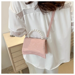 Pink pearl handle hourglass bag detail showing glossy patent leather and arched base
