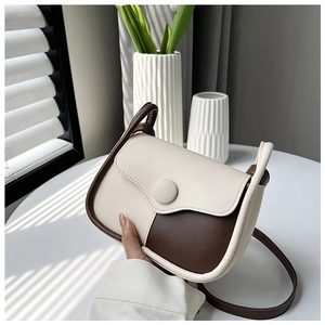 Detail of the minimalist retro crossbody bag showing the cream and brown contrast colors