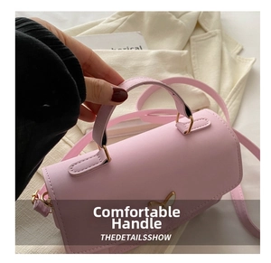 Detail of pink quilted square bag featuring a butterfly metal clasp and top handle