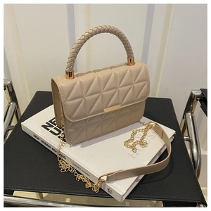 Detail of beige quilted crossbody bag with woven handle and gold chain strap