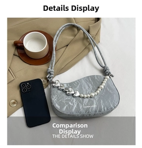 Detail of grey pleated shoulder bag with silver heart charms and pearl chain strap