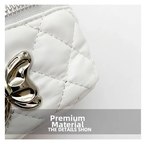 Detail of white quilted leather bucket bag with silver butterfly clasp and metal zipper