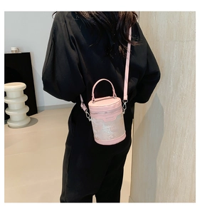 Vista posteriore dettagliata del modello che indossa la borsa a secchiello rosa a cilindro