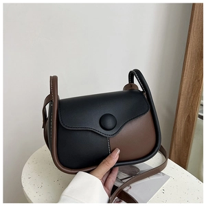 Close-up of vintage bicolored crossbody bag with contrast stitching and large round buckle