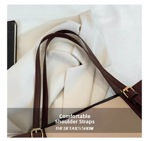 Detail of adjustable dark brown leather shoulder strap with premium golden metal buckle