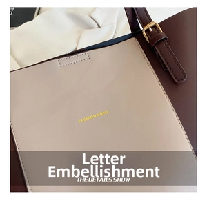 Detail of contrast stitching, gold buckle hardware and fashion logo on PU leather tote bag