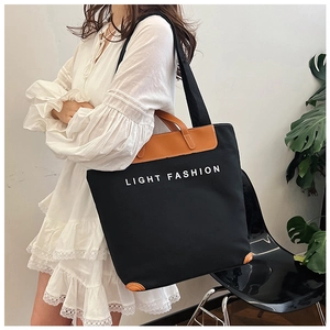 Detail of canvas tote bag with Light Fashion print and brown leather corner reinforcements