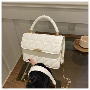 Close-up of white quilted PU leather bag with golden chain and woven handle