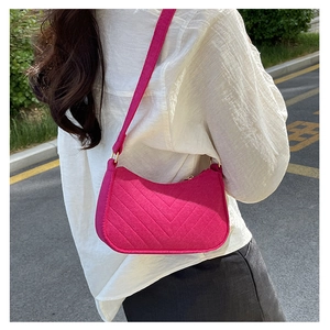 Detail of rose pink quilted hobo bag with V-shaped stitching and golden hardware