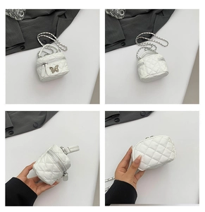 Detail view of white quilted mini bag with metal bow clasp and chain strap
