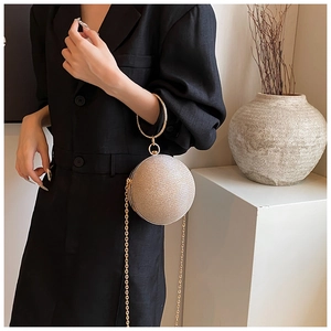 Champagne gold spherical clutch bag with round metal handle and delicate glitter finish