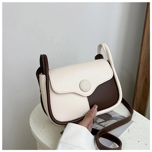 Detail of a minimalist square crossbody bag in off-white and dark brown color block