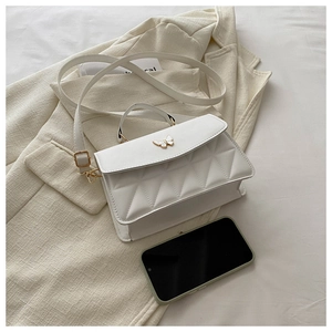 Close-up of white quilted PU leather crossbody bag with elegant enamel butterfly buckle