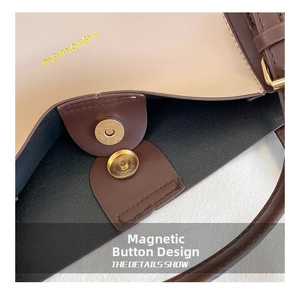 Detail of magnetic snap closure on two-tone brown and beige PU tote bag with gold logo