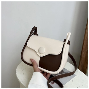 Detail of a vintage-style saddle bag with beige and brown contrast stitching and round clasp
