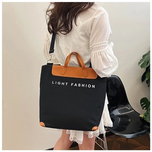 Detail of canvas tote bag with leather trim and Light Fashion print on a model